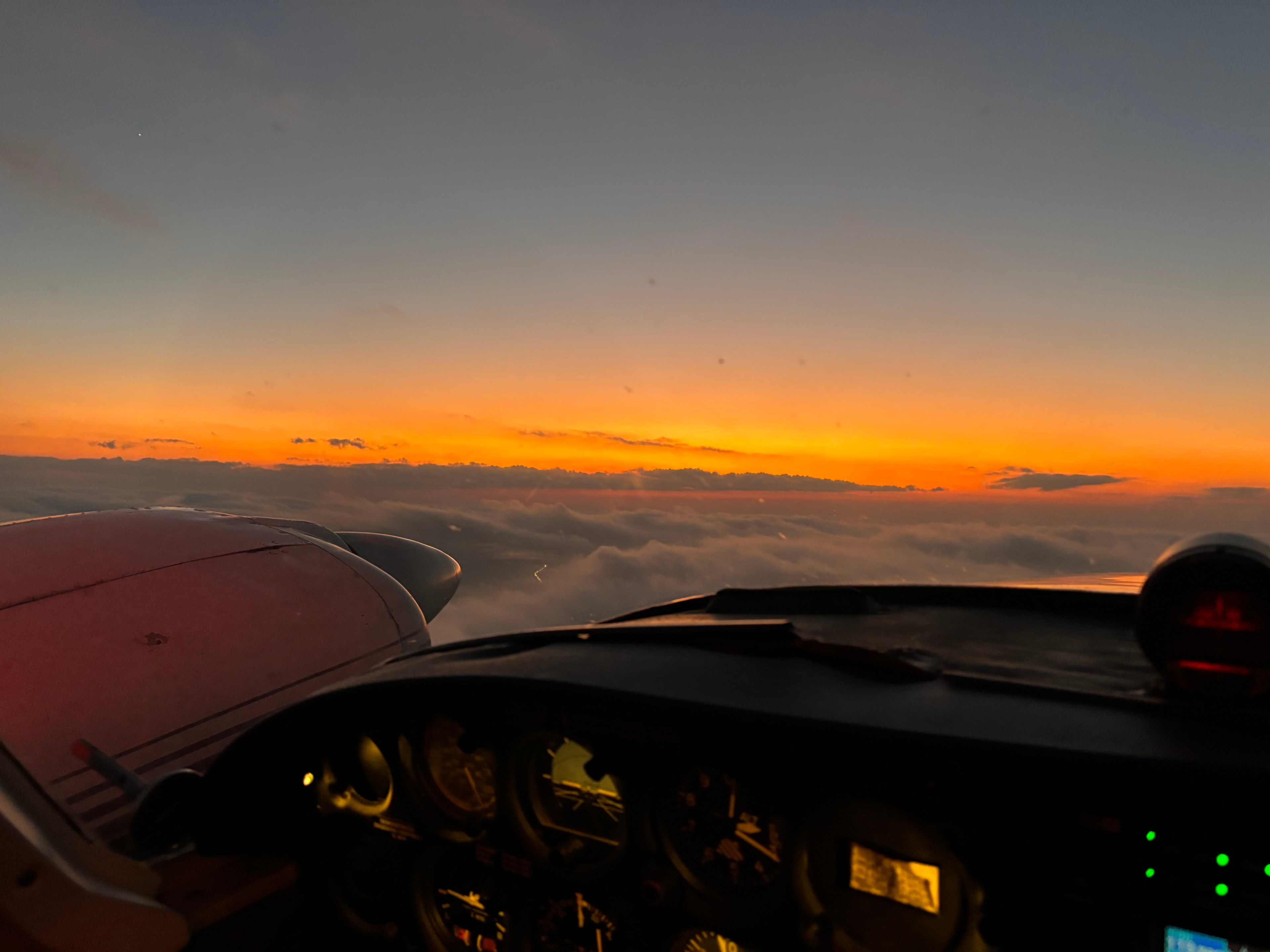 Sunset view from aircraft cockpit above the clouds